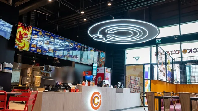Comptoir d'un restaurant Chick & Cheez : menus digitaux et luminaire circulaire