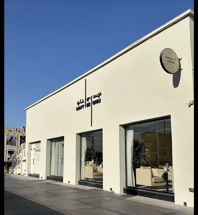 Façade blanche de Don't Be Chai avec l'enseigne bilingue en arabe et en latin, sous un ciel bleu
